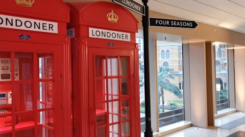 Young Man Entering Red Phone Booth