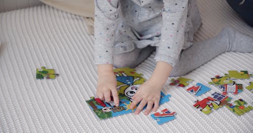 Cute Girl Solving a Jigsaw Puzzle