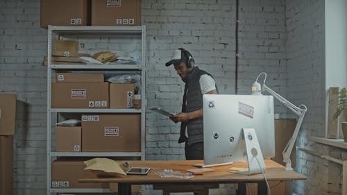 Man Enjoying the Music While Working in the Storage Room of the Parcels