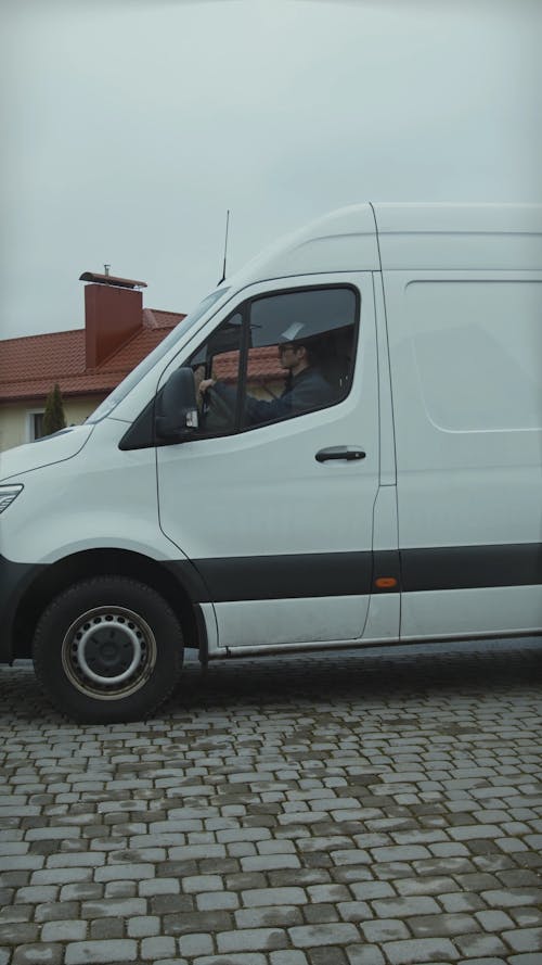 A Delivery Man Stepping out of a White Van