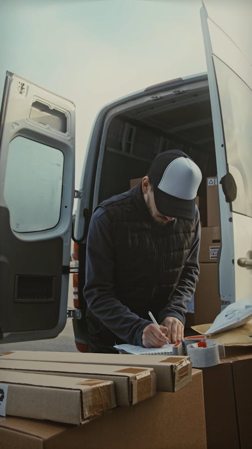 Delivery Guy Making Entry in the Notepad