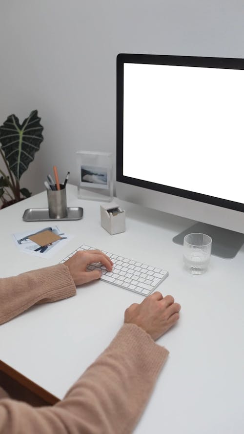 Person Working on a Desktop with White Screen