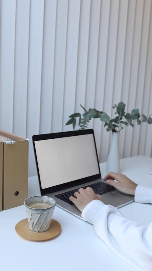 Person Working on Laptop with White Screen