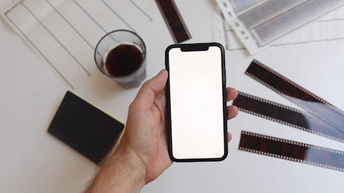 Person Holding an iPhone with a Blank Screen