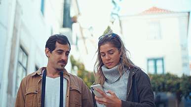 man and woman taking selfies together