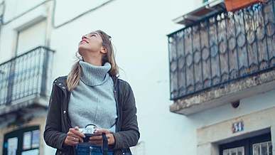 a woman looking around then taking a selfie
