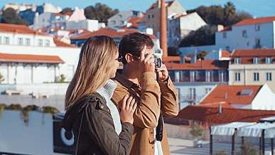 man taking pictures of the view using an analog camera