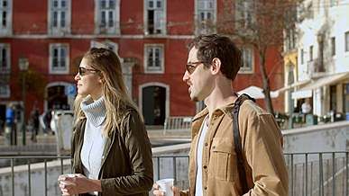 man and woman walking on street while talking