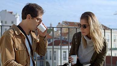 man and woman drinking coffee looking to a map