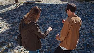 man and woman wearing sunglasses dancing on the pavement