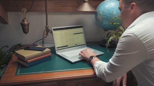 Man Sending an Email with a Laptop