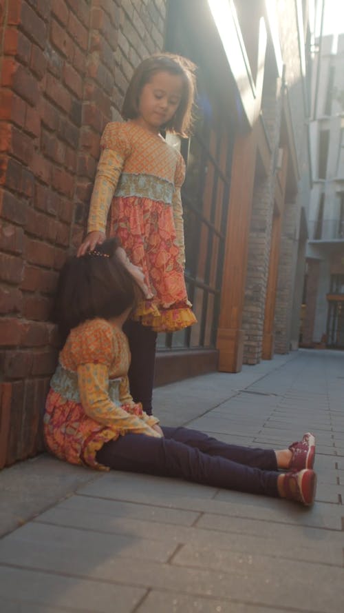Two Girls Wearing Floral Dresses Playing Outside