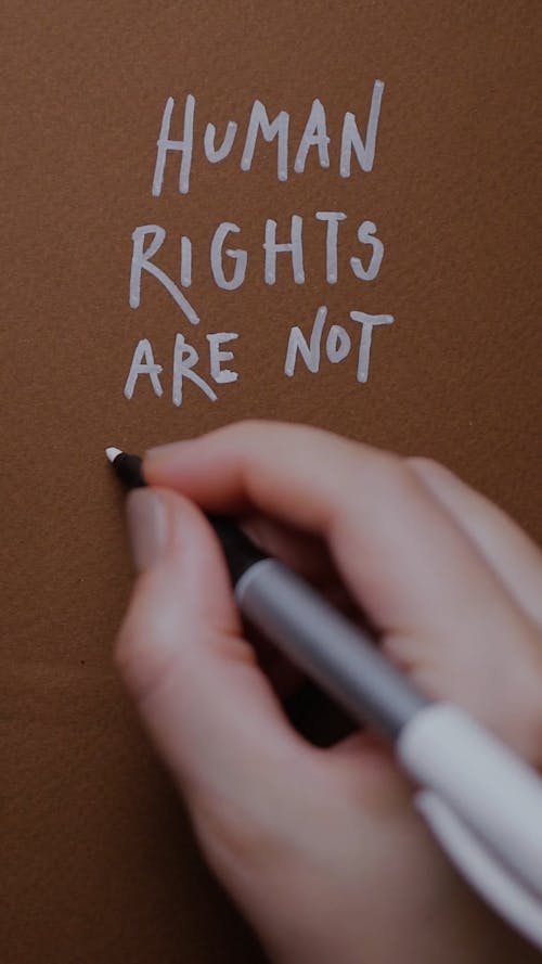 A Person Writing a Phrase on Brown Paper