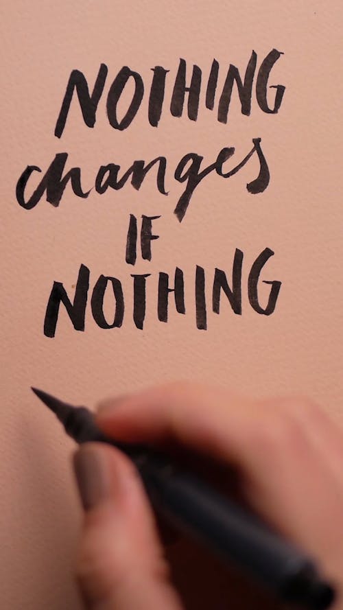 A Person Writing the Word Changes on a Paper