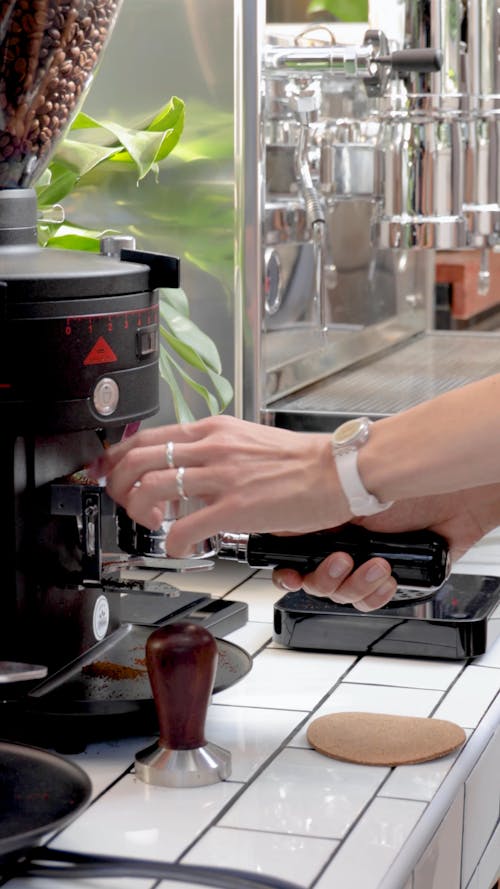 A Person Grinding and Weighing Ground Coffee