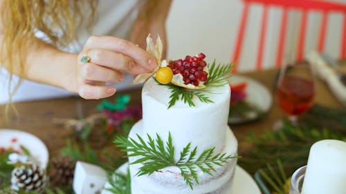 Woman Putting Decoration on a Cake