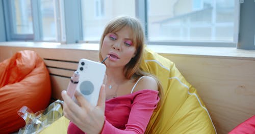 Woman puts on Make-up by the Window