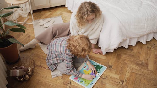 A Mother and Son Playing Puzzle on the Floor