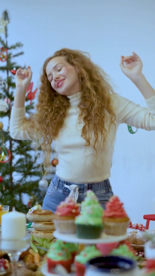 Person Dancing Next to Table and Christmas Tree