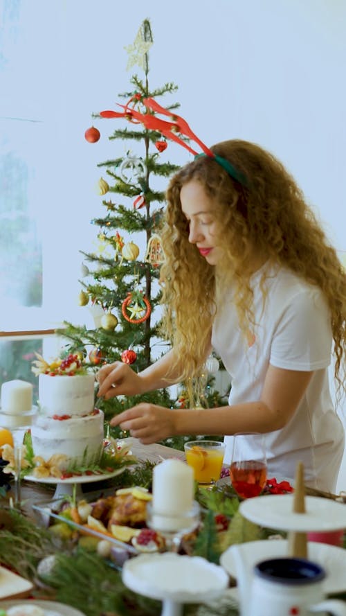 Woman Decorating Christmas Diner Table