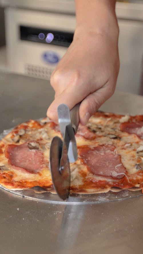 Person Slicing a Pizza