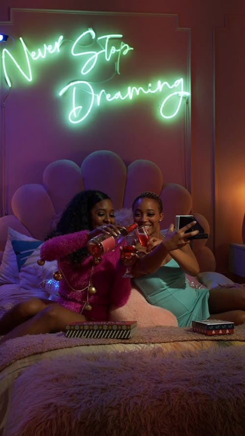 Two Ladies Drinking Wine In Bed