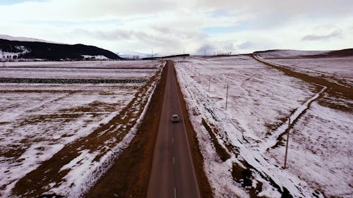 Car Moving on the Road Surrounded with Snow