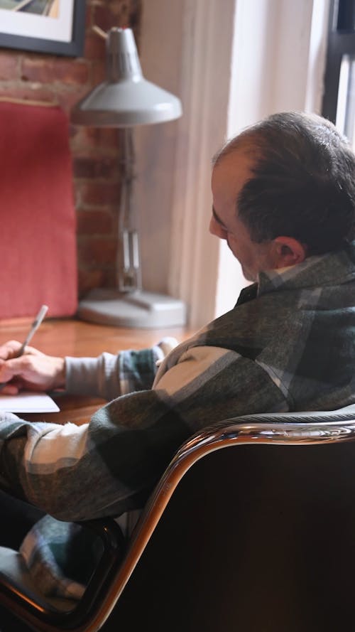 Man Writing on Notebook