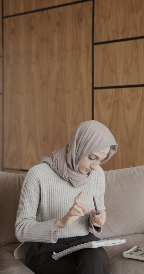 Muslim Girl Taking Notes on the Couch