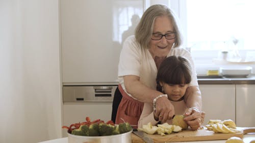 Grandmother Teaching Granddaughter How to Core Apple