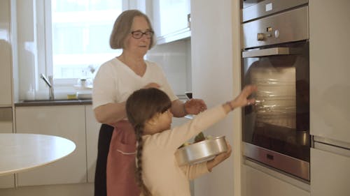 Elderly Woman and Little Girl Cooking Together 