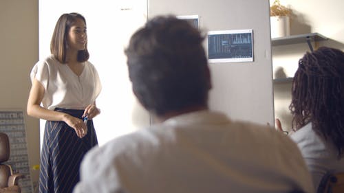 A Woman Talking to a Coworker at a Meeting