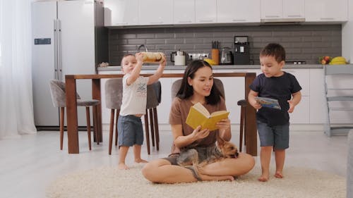 Woman Reading Books to Her Children