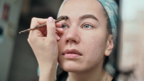 A Woman Preparing Her Eyebrows with Beauty Products