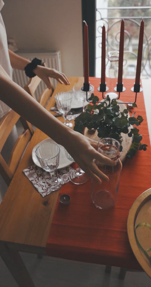 A Woman Arranging the Dining Table