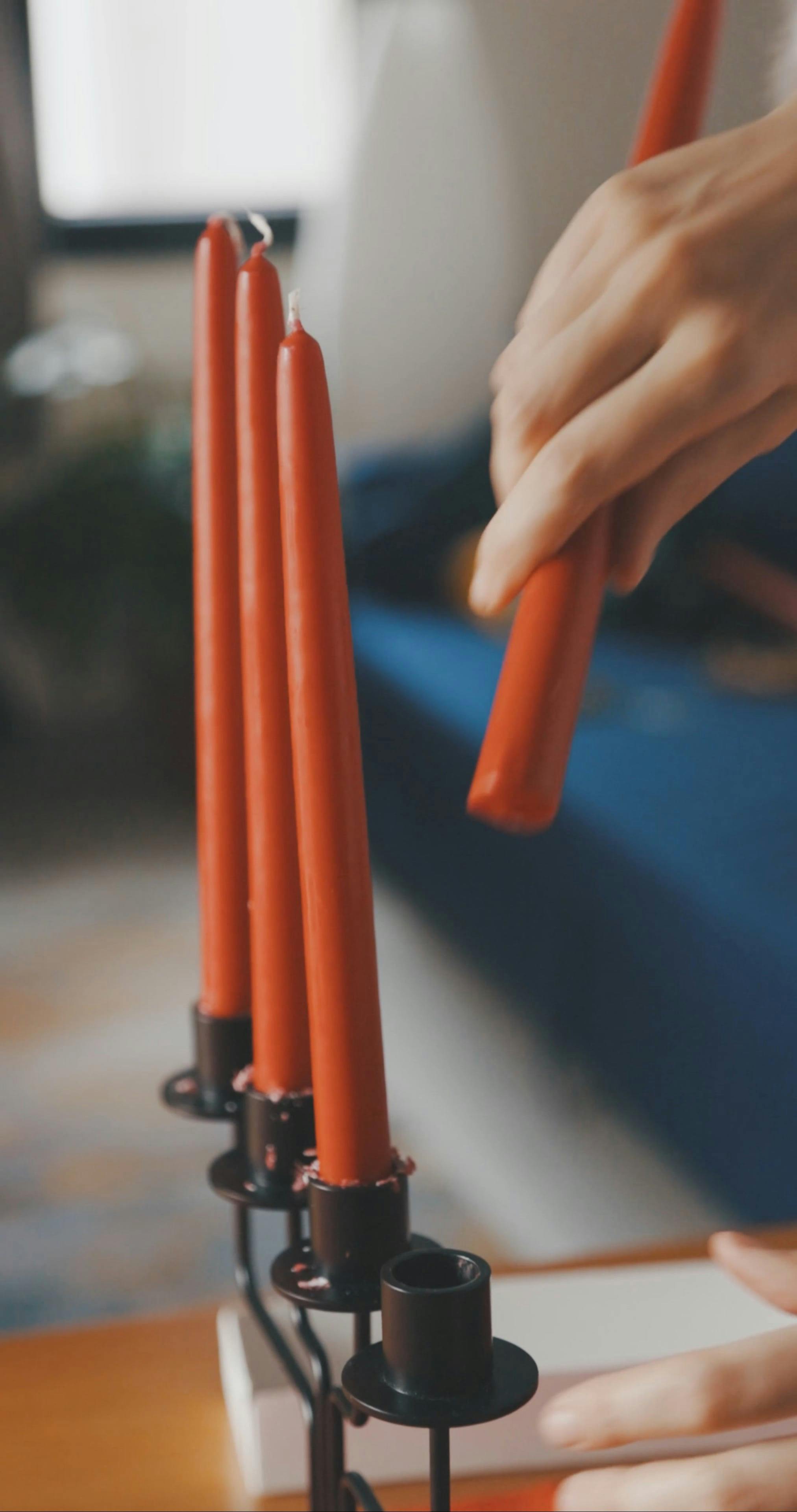 A Person Putting a Red Candle in a Candle Holder · Free Stock Video