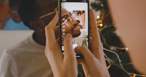 A Man Having a Picture Beside the Christmas Tree