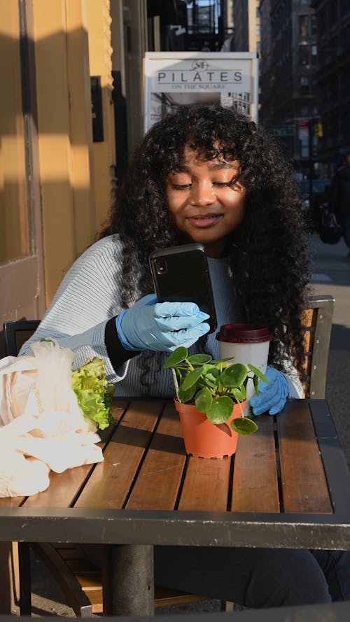 Woman Taking Photo of Small Plant