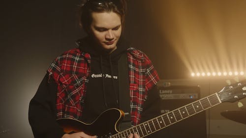 Man Playing the Guitar in a Show 