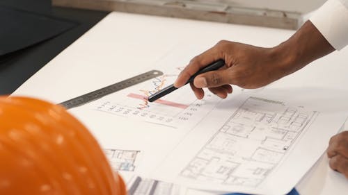 An Architect Looking Over a Building Blueprint