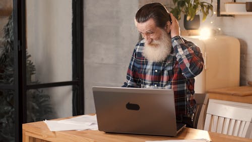 An Elderly Man Typing on his Laptop