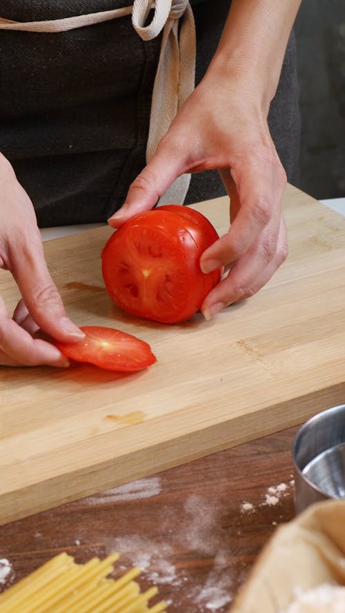 A Person Arranging a Sliced Tomatoes