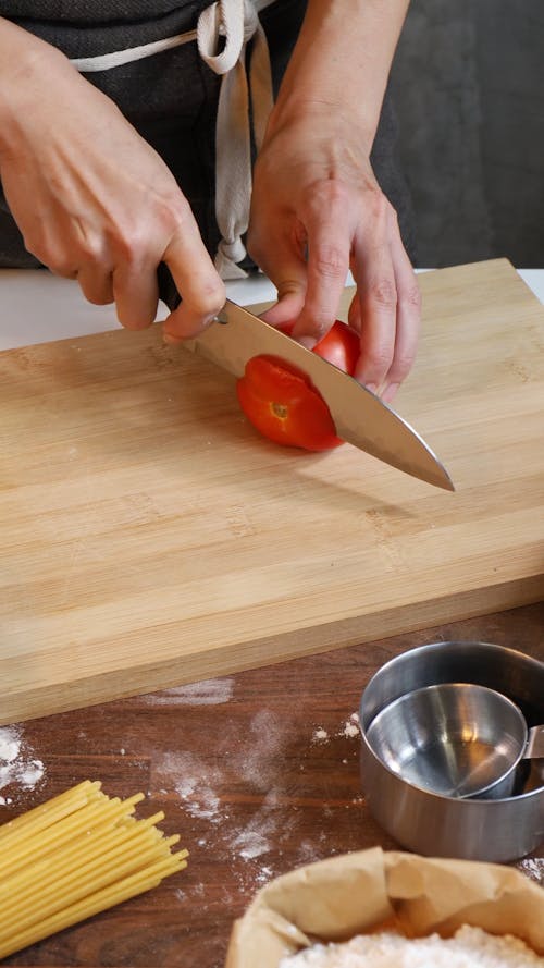A Person Slicing a Tomato