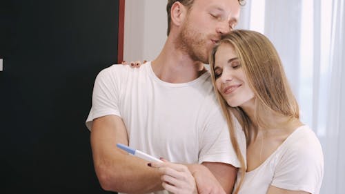 Young Couple Holding Looking at Pregnancy Test 