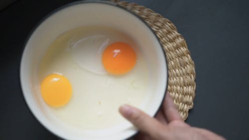 A Person Mixing Eggs on a Cooking Pot
