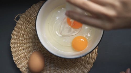 Person Putting Egg on a Bowl