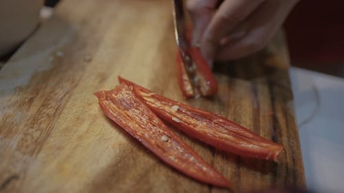 A Person Slicing a Red Chili Pepper