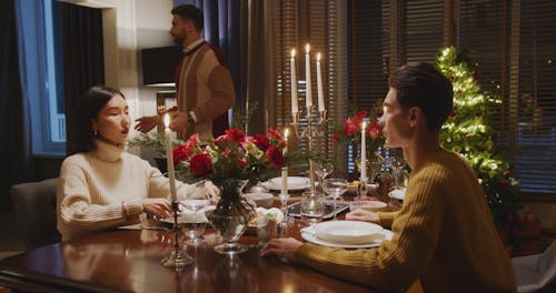 Couple Bringing Dishes To Dining Table