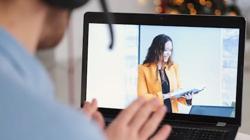 A Woman Reading a Book on a Laptop Screen