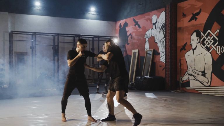 Two fighters sparring in a gym under low light